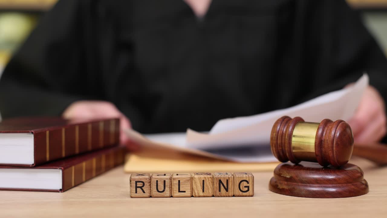 Image of a gavel, books, and the word 'RULING' spelled out in wooden blocks
