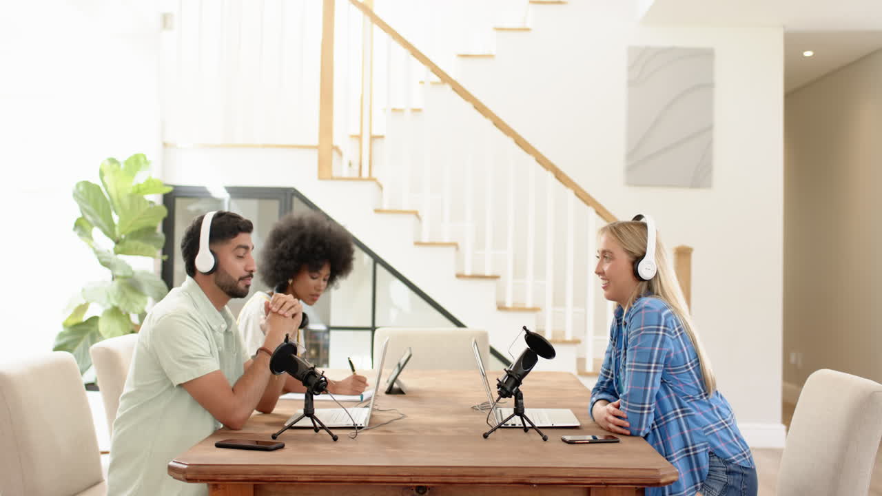 Recording podcast, young friends using microphones and headphones at table