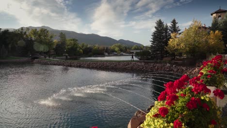 Gorgeous-lake-front-mountain-hotel-property-framed-by-beautiful-roses,-landscaping,-and-fountain-accents