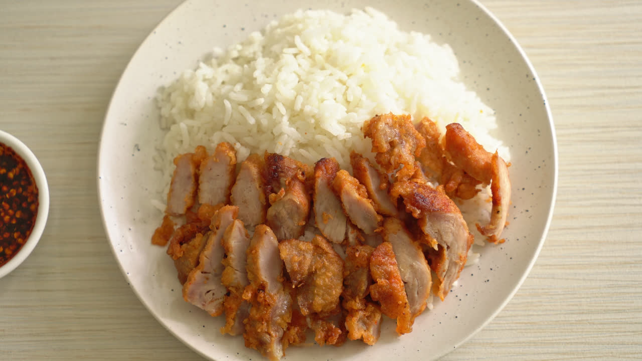 매콤한 디핑 소스를 얹은 밥 위에 튀긴 돼지 고기