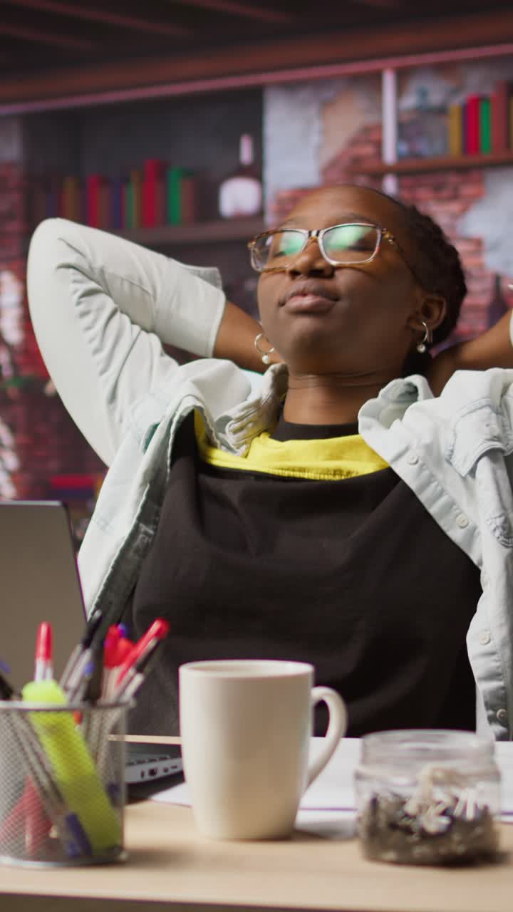 Vertical video Woman watching movies at home on laptop, drinking coffee