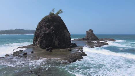 island rock hit by powerful ocean, aerial view