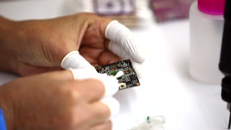 the engineer cleans the motherboard with a cotton swab