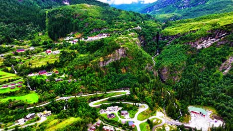 vista aérea del pueblo de geiranger, ruta panorámica y paisaje verde sobre el fiordo, noruega