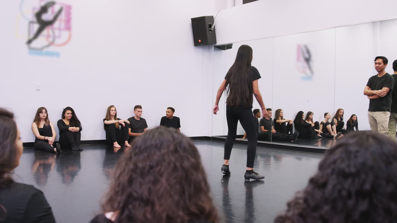 estudiante de tap dance en una escuela de artes escénicas actúa para la clase y el maestro en el estudio