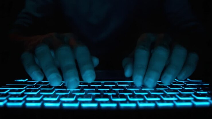 Illuminated Keyboard: A Close-Up View of Hands Typing in a Dark Environment Highlighted by the Glowing Keys, Depicting the Intricacies of Modern Technology and Communication