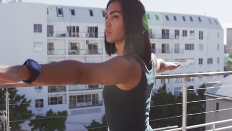 Mixed-race-gender-fluid-person-practicing-yoga-meditation-on-roof-terrace