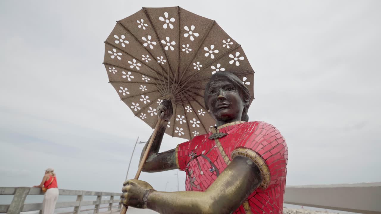 Sculpture honoring chinese immigrants on the famous pier of puerto colombia, a historic landmark