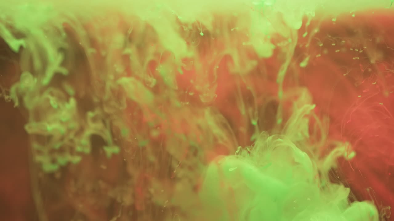 video de primer plano de tinta verde y roja en el agua con espacio de copia