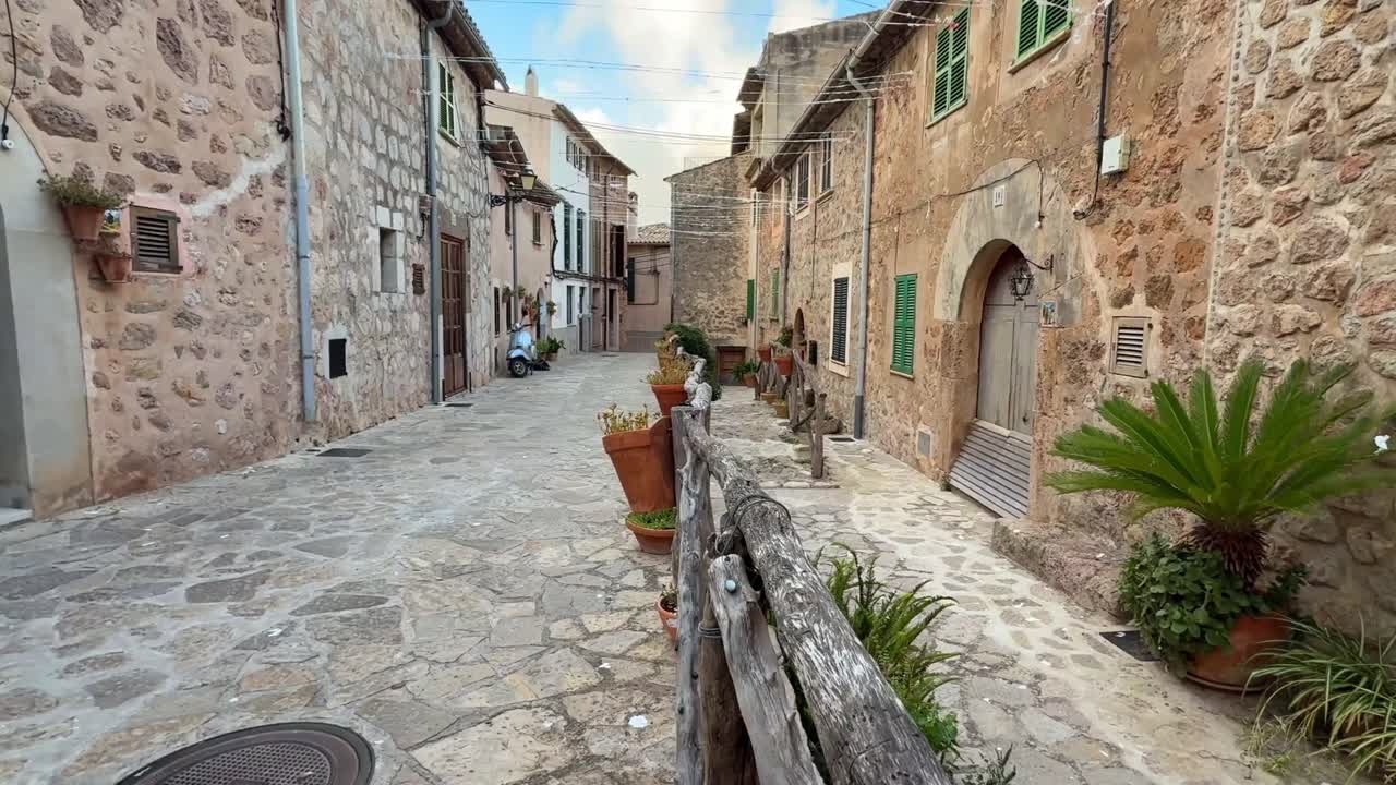 Stretta via acciottolata con case tradizionali in pietra nel villaggio di Valldemossa, Maiorca, Spagna