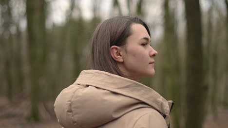 a young girl walks through the forest looking from side to side