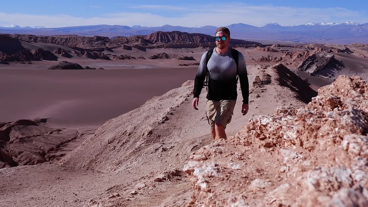un hombre solitario camina a lo largo del desierto de atacama en la cima de la cresta de grava de la montaña en chile