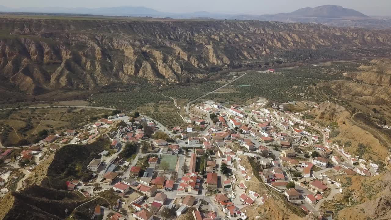 vista aérea de una ciudad en españa en el desierto con un gran acantilado en el horizonte