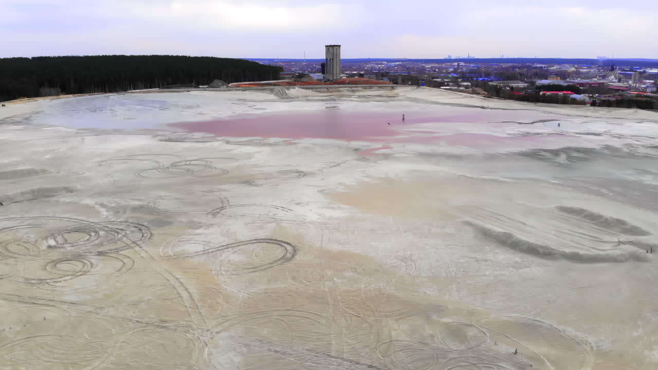 Luftfoto af industrielt tailings-bassin med rødt, giftigt vand