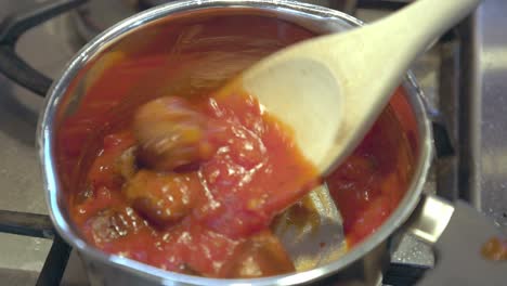 toma de primer plano de albóndigas añadidas a una salsa de tomate en una sartén