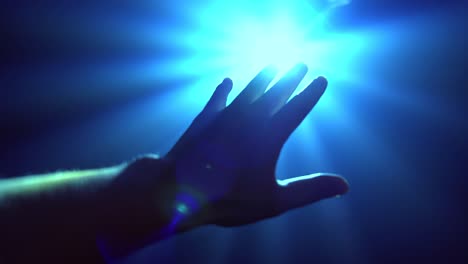 la mano extendiéndose para cubrir la luz del punto brillante