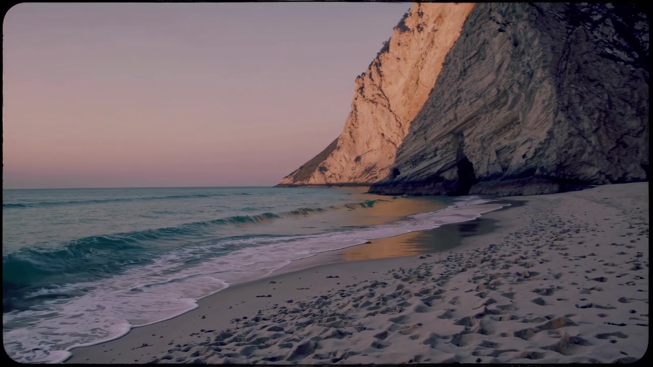 Gentle Waves Rolling onto a Sandy Beach at Sunset