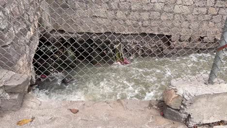 el canal de desechos a lo largo del costado de la carretera está siendo drenado de su agua gris llena de lodo