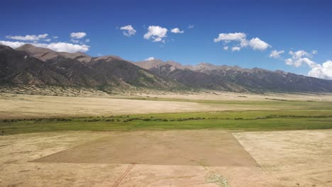 Rocky-Mountains-in-Colorado-during-the-fall-with-rural-farmlands,-aerial-pan