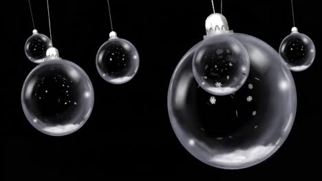 animation of christmas baubles dangling with snow falling on black background