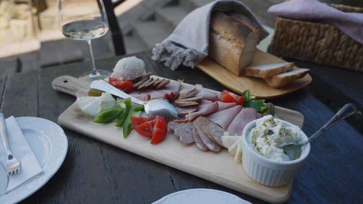 Gourmet charcuterie board with meats cheese and wine in outdoor dining setting
