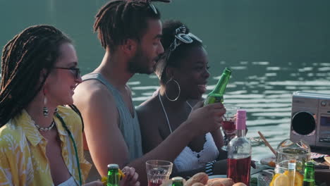 multiethnic couple smiling and chatting at lake party