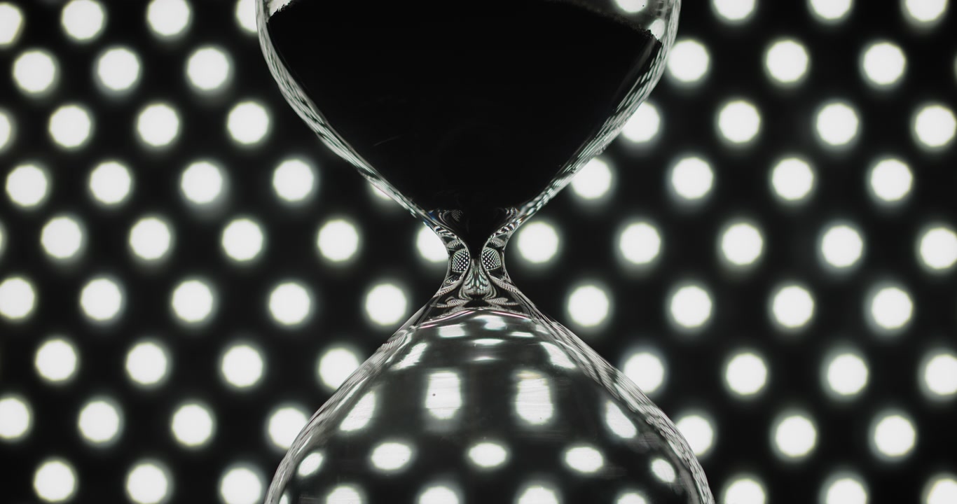 Hourglass on background of bokeh lights