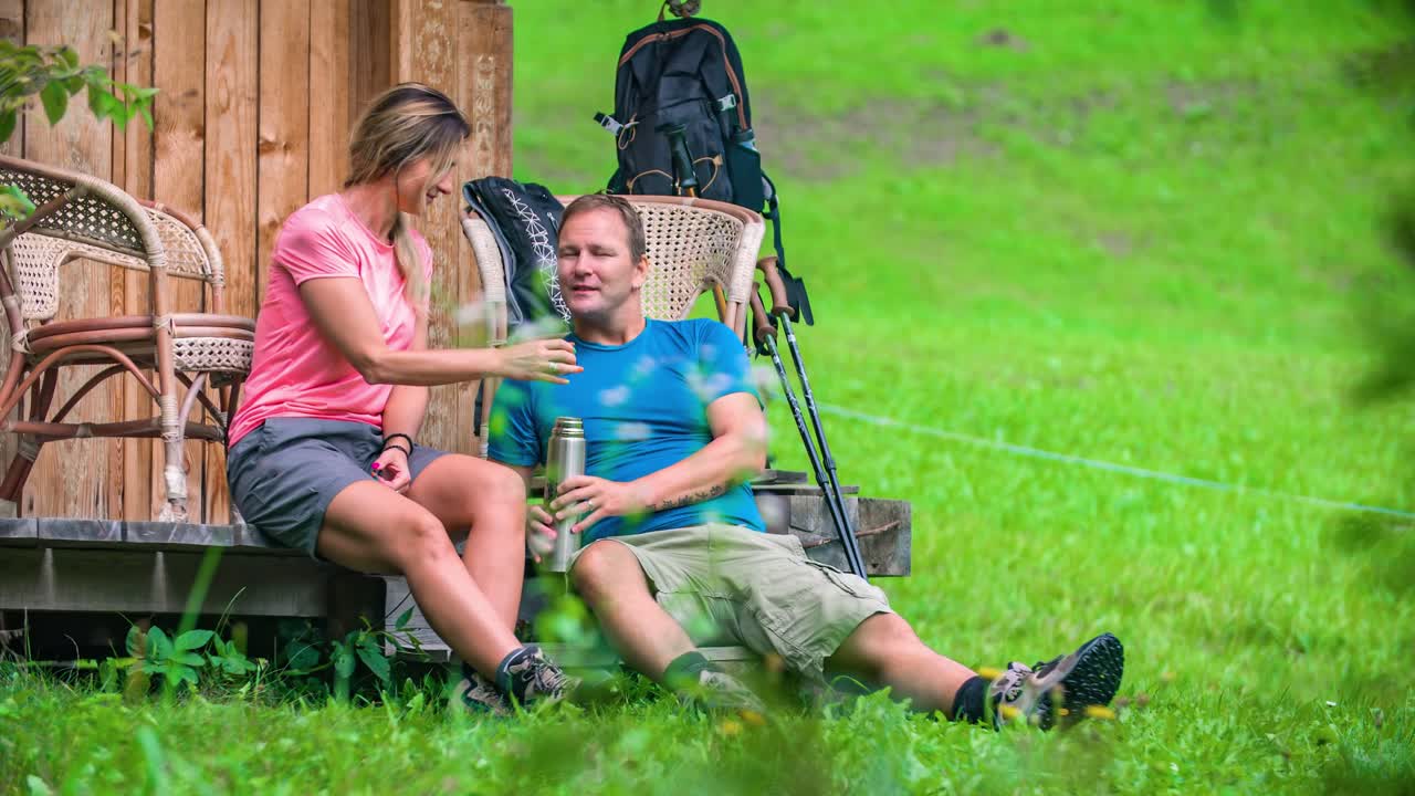 Young attractive couple drinks morning coffee before hiking
