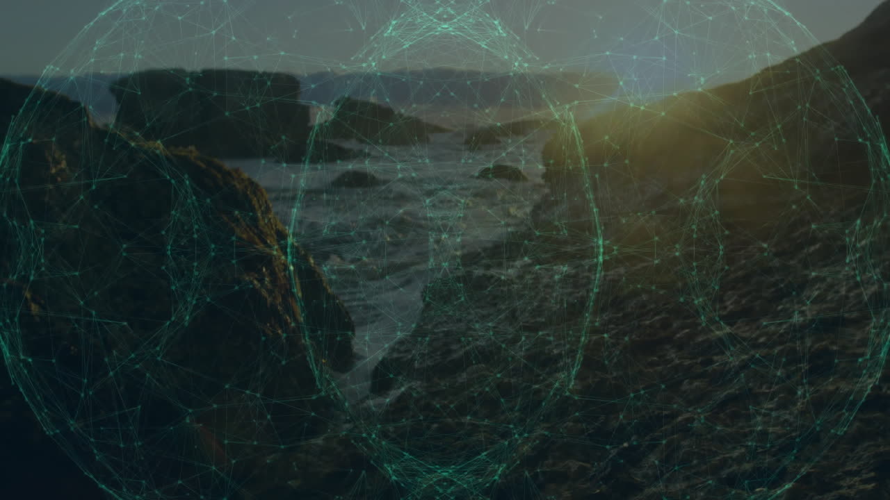 Ocean at sunset with digital network animation overlaying rocky coastline