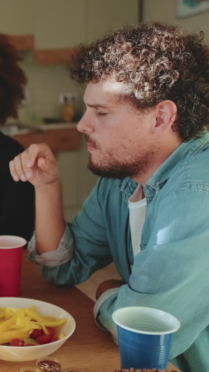 Hombre con pelo rizado y camisa vaquera en una fiesta