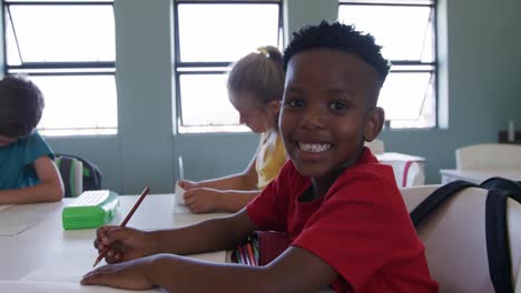 Niño-Sonriendo-Mientras-Está-Sentado-En-La-Clase