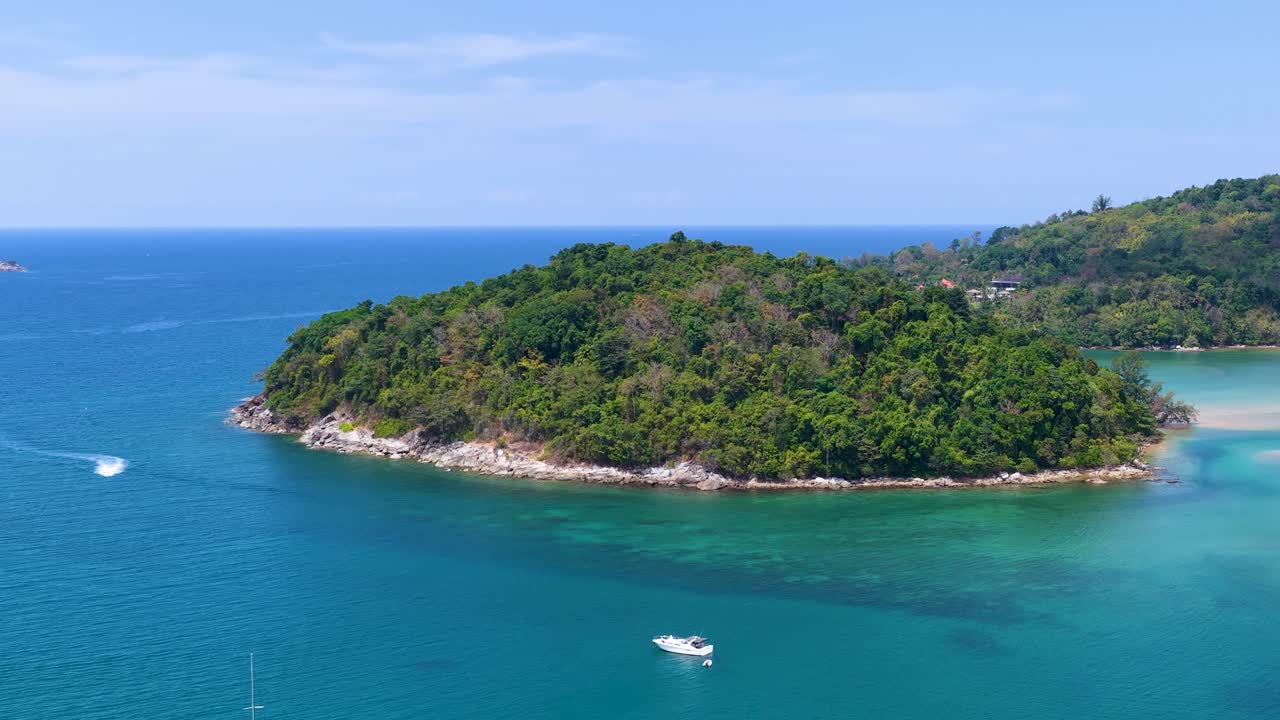 Aerial drone shot of sailboats and yachts anchored in turquoise water near a tropical island