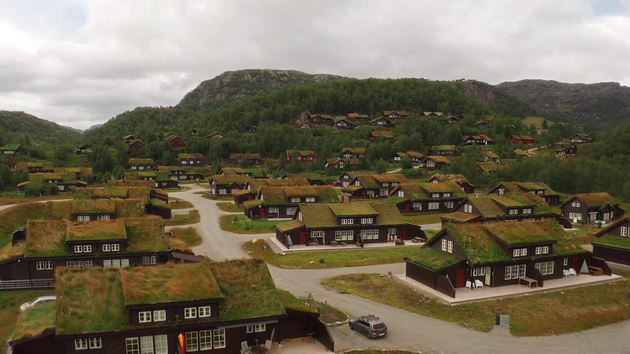 Green-roofed wooden houses in Norway’s scenic countryside, nestled in nature