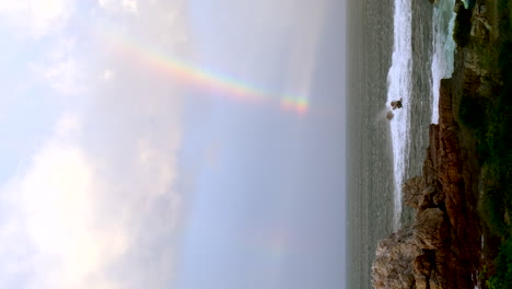 double rainbow over a dramatic ocean coastline