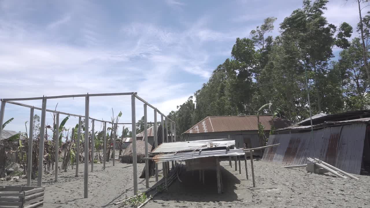 Wide view of some riverside broken houses after the flood from a Bangladeshi village.