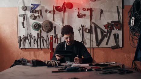 trabajador metalúrgico usando una tableta en un taller