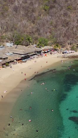 Vista-Aérea-Vertical-En-Cámara-Lenta-De-Las-Playas-De-Huatulco,-Oaxaca,-México.