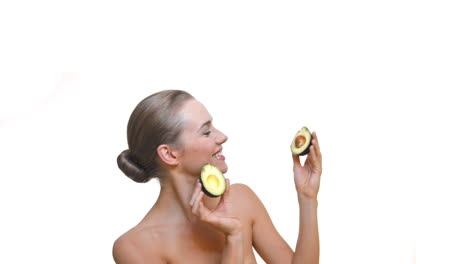 joyful lady hold an avocado as a pure cosmetology product for soft skin, bodycare, and weight control for feminine
