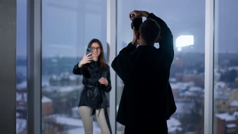 Photographer taking pictures of a model in a city view studio.