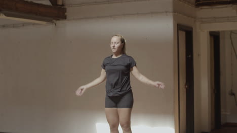 slow motion of young woman doing jumping jacks in gym