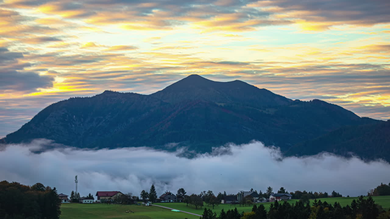 Kabut yang terbentuk di pagi hari di sekitar pegunungan dekat Danau Attersee Austria