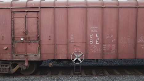 Perpendicular-shot-of-red-trains-passing-by-in-India