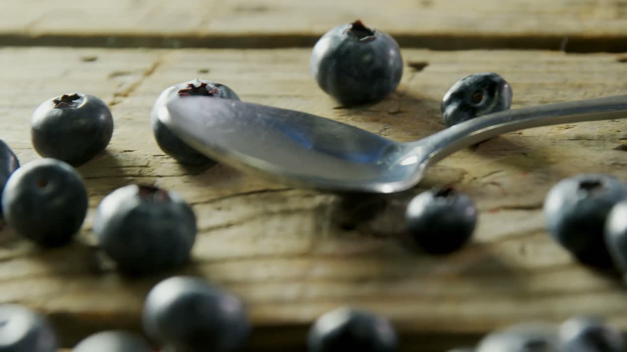 Fresh blueberries and spoon on wooden table 4k