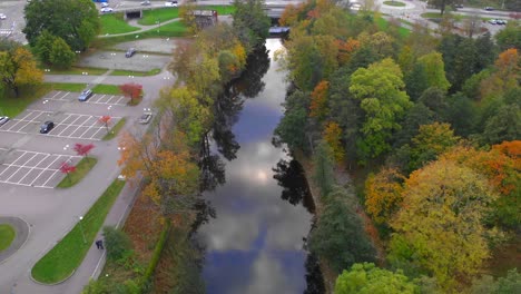 aerial view of river running through city with trees in fall colors