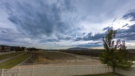 In-Diesem-Ruhigen-Zeitraffer-Einer-Wolkenlandschaft-über-Einer-Wiese-Wehen-Cirruswolken-In-Eine-Richtung,-Während-Kumuluswolken-In-Eine-Andere-Richtung-Wehen