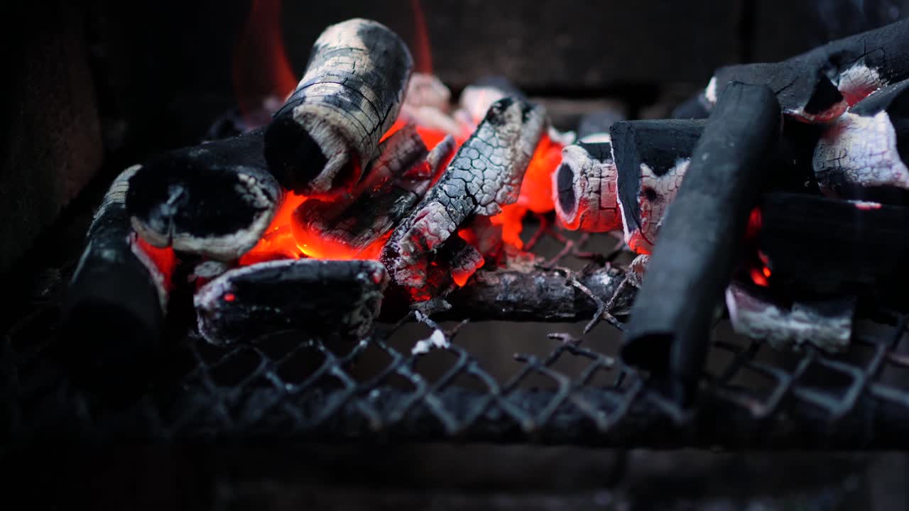 hot charcoal burning in the grill with flames, ready to start cooking bbq. zooming shot.