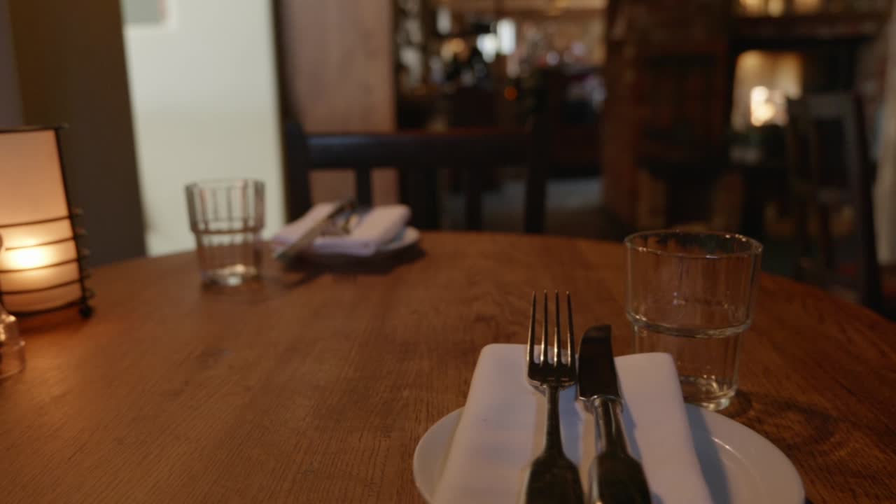 Inquadratura media di posate e posto vuoto al tavolo di un pub ristorante.