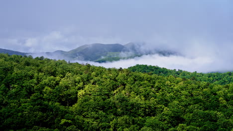 slow cinematic drone flight into a fog-filled mountain scene