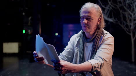 old man sitting on a chair at the stage