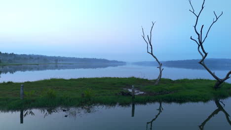 morning calm lake , before sun lake reflecting the atmospheric effects of the sky and surrounded by misty-fogs